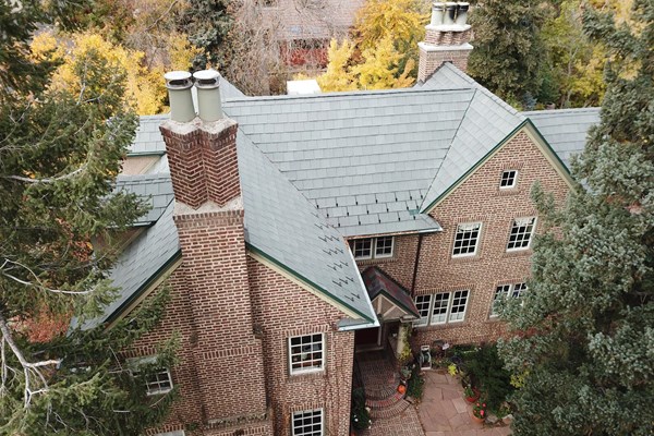 house with a light green colored roof from our roofers in colorado